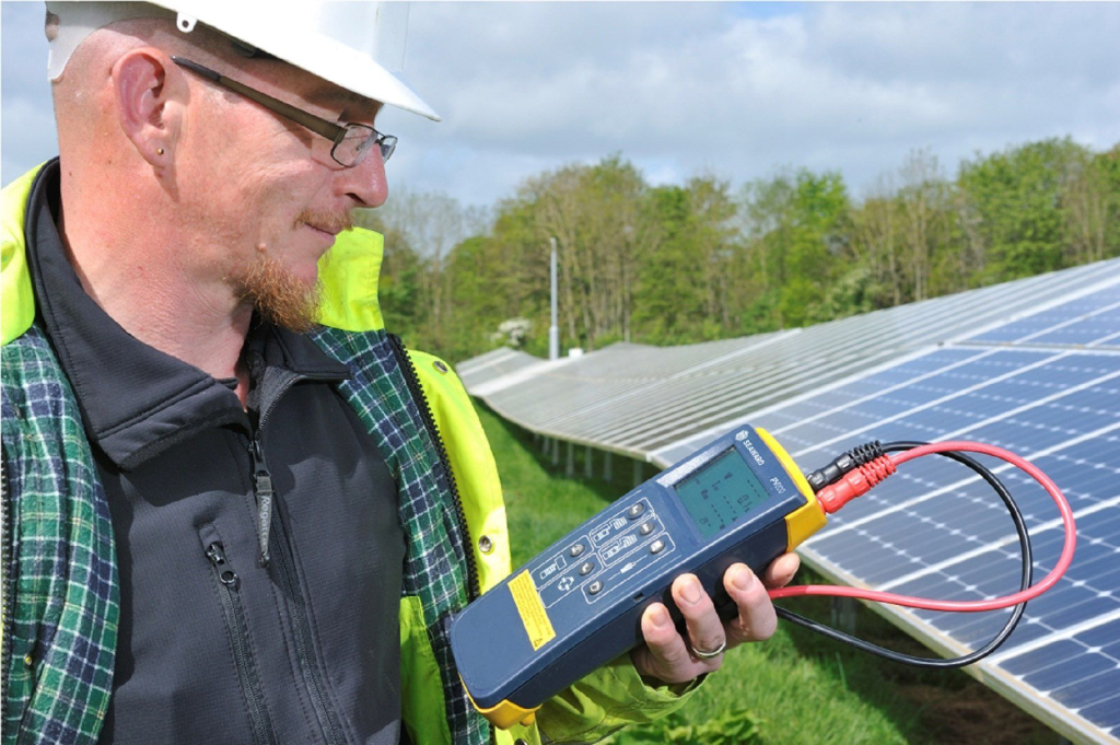 Person monitoring solar panel performance on a tablet